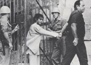 看守長ハミドウ（ポール・スミス）に手を引かれ