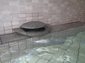 大浴槽に源泉を注ぐ湯口の写真