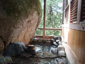 巨岩が眼前に迫り出すワイルドな露天風呂の写真